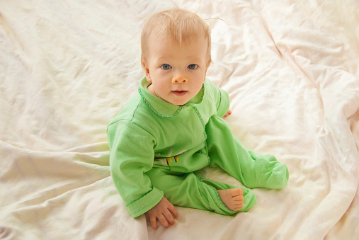 Baby In A Sleeping Clothes In A Bed Just Wake Up Stock Photo - Download ...