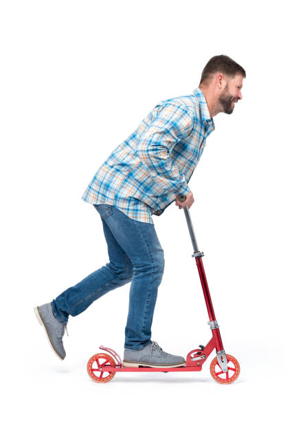 istock Happy bearded man rides a red kick scooter, isolated on white background. Side view. 1175512215