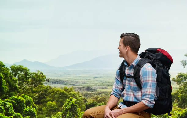 One man only / one person / waist up / side view / profile view of 30-39 years old adult handsome people caucasian male / young men backpacker / tourist / tourist hiking / standing / resting in front of nature in the woodland who is outdoors wearing lumberjack shirt / plaid shirt / button down shirt / shirt / khaki pants / backpack who is smiling / happy / cheerful and holding plant / leaf / using hiking pole / sky / wilderness area / forest un hombre sólo / una persona / cintura para arriba / vista lateral / vista de perfil de 30-39 años adultos guapopersonas caucásicos hombres / hombres jóvenes mochilero / turista / senderismo turístico / de pie / descansando frente a la naturaleza en e