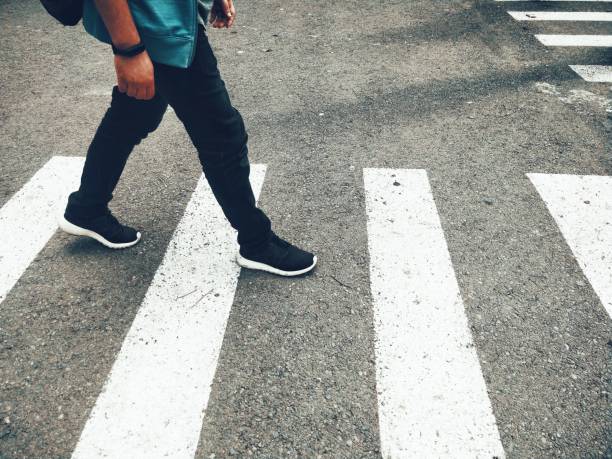 istock Low Section Of Man Walking On Crosswalk 1175514284