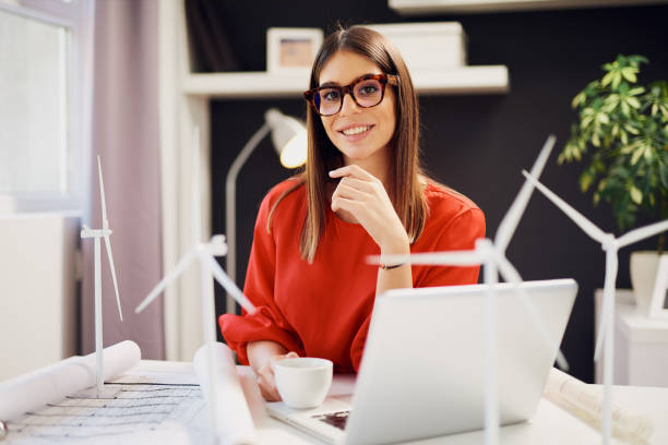 Buinesswoman holding coffee while sitting in office.