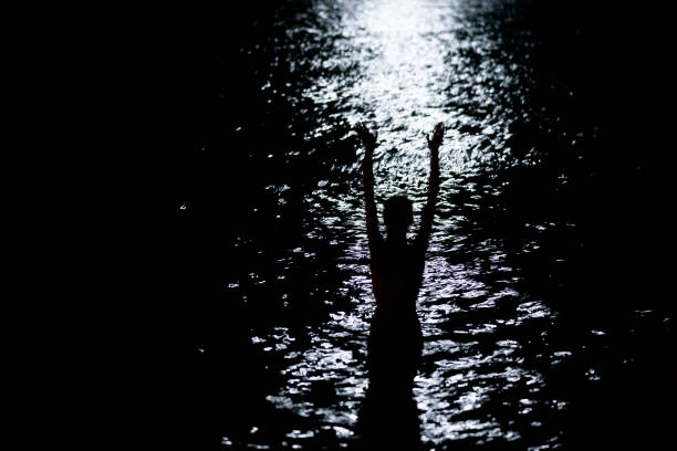 Female silhouette in water on a full-moon bight