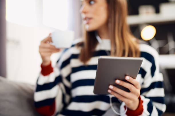 istock Woman using tablet and drinking coffee in bedroom. 1175515033