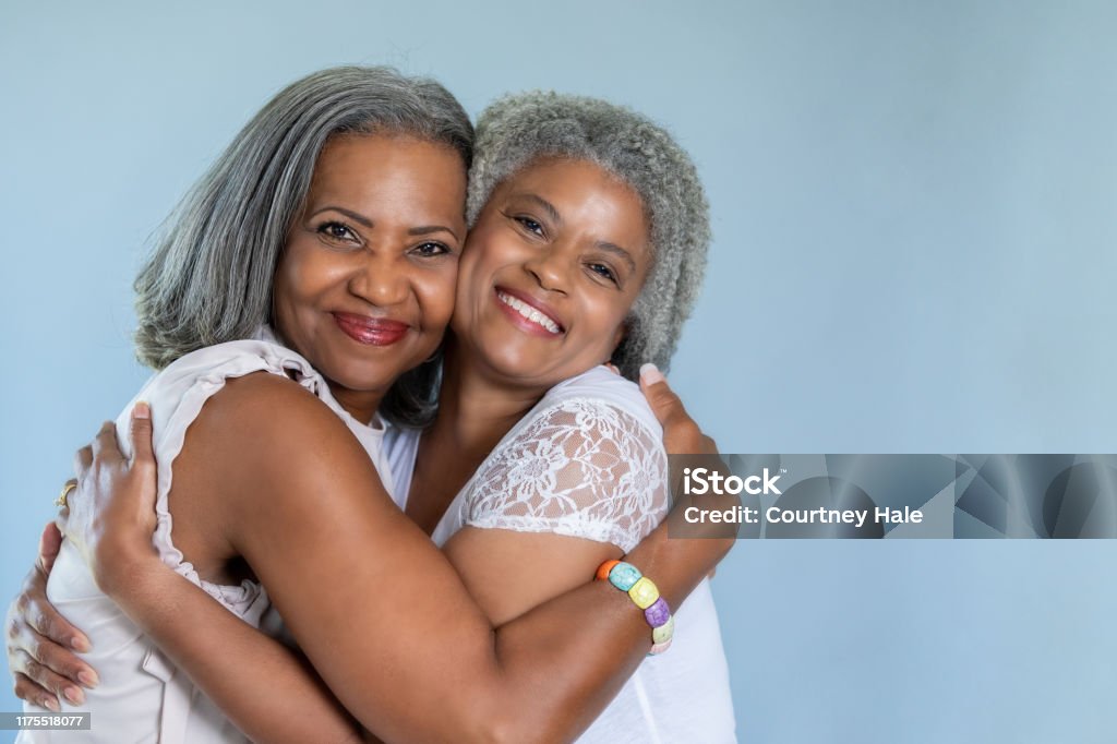 Beautiful black senior women embrace in a hug Sister Stock Photo