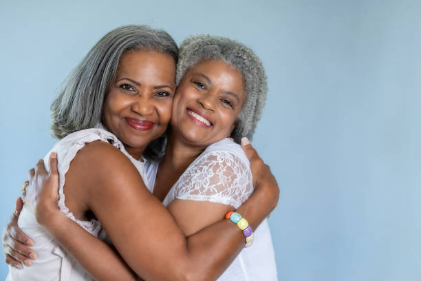 Beautiful black senior women embrace in a hug Beautiful black senior women embrace in a hug gray hair photos stock pictures, royalty-free photos & images