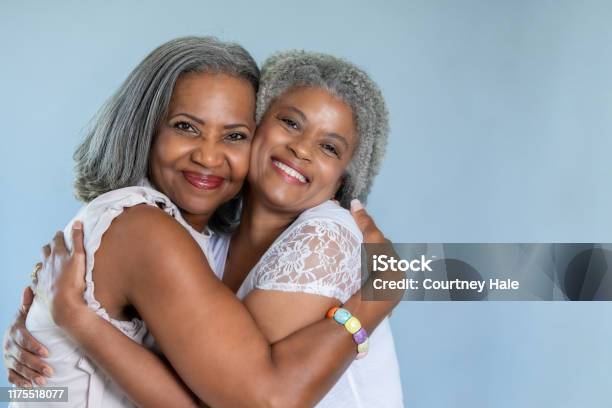 Beautiful Black Senior Women Embrace In A Hug Stock Photo - Download Image Now - Sister, Senior Adult, African-American Ethnicity