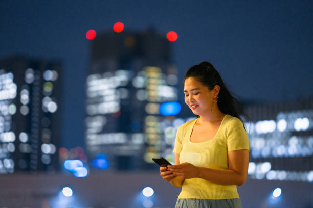 istock Young and happy woman using smart phone at night 1175518664