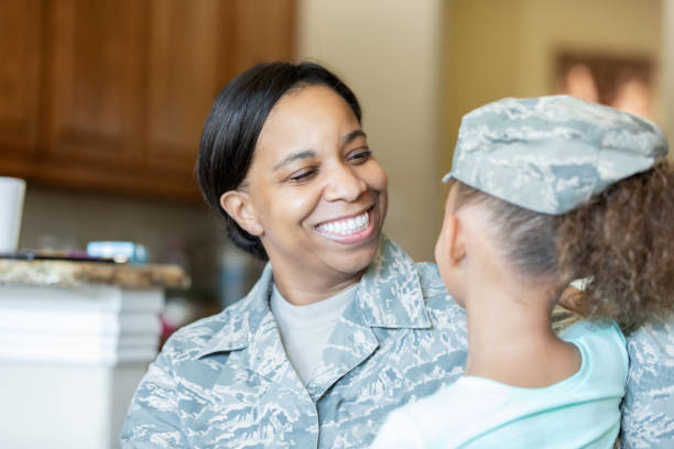 istock Female soldier greeting elementary age daughter at home 1175525060