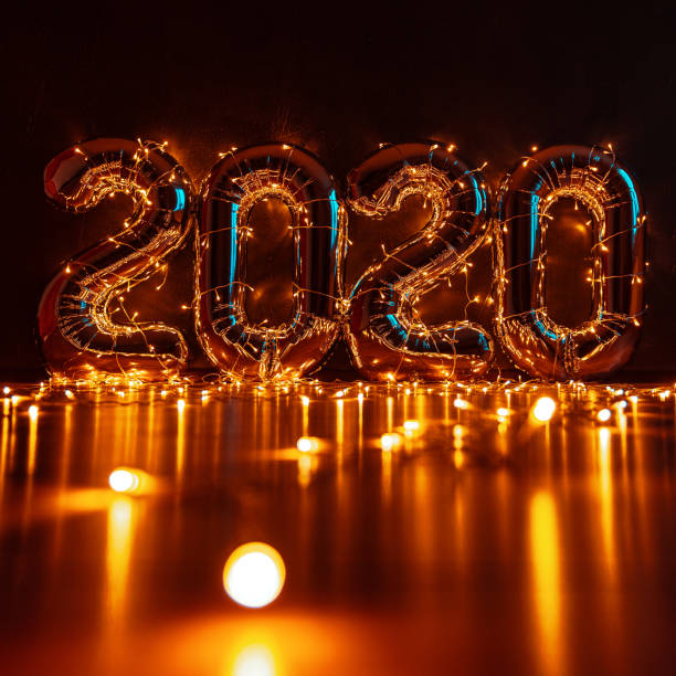 istock voluminous inflatable figures 2020 against a dark wall, wrapped in Christmas lights with beautiful highlights and a place for text 1175531397