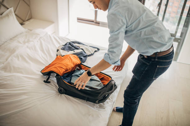 istock Man Packing Holiday Suitcase  In Bedroom 1175532445