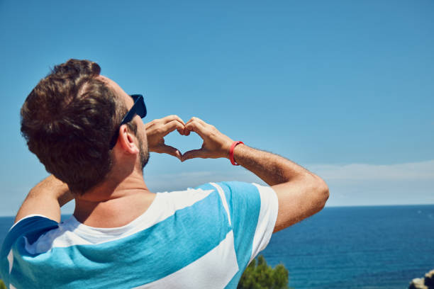 istock Man making heart shape with hands on tropical beach. 1175534167