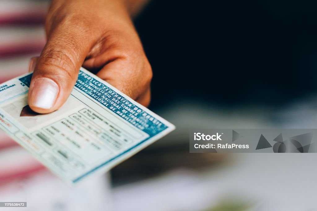 Man holds National Driver's License (CNH). Official document of Brazil, which attests the ability of a citizen to drive land vehicles Man holds National Driver's License (CNH). Official document of Brazil, which attests the ability of a citizen to drive land vehicles. Driver's License Stock Photo