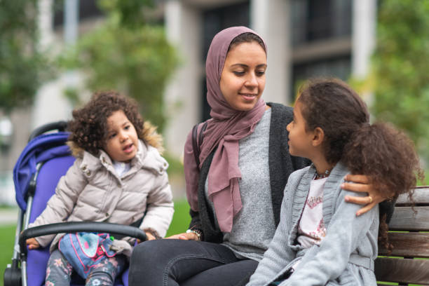 istock Middle Eastern family sitting on park bench 1175539105