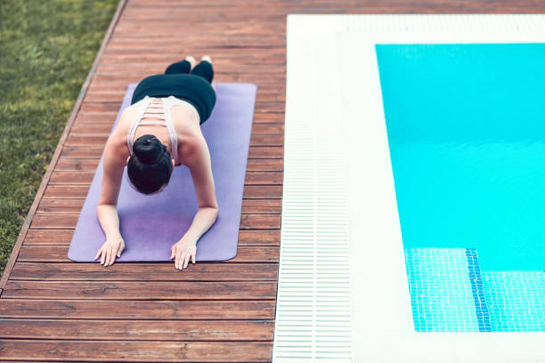 istock Female Athlete Doing Plank Exercise By The Pool 1175546171