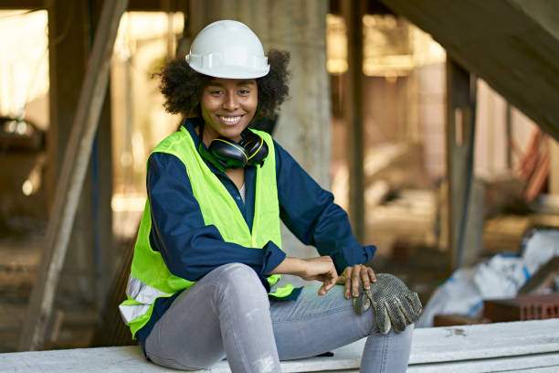 istock Smiling female engineer sitting on plank at site 1175551927