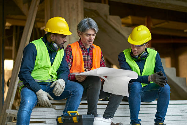 istock Multi-ethnic coworkers discussing over blueprint 1175551929
