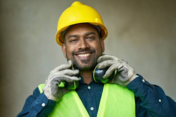 Close-up portrait of confident male engineer Close-up portrait of confident male engineer. Building contractor is wearing protective workwear. He is working at construction site. ear protectors stock pictures, royalty-free photos & images