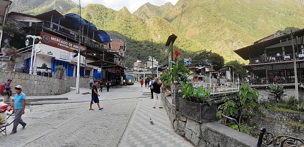 Scene Of Andes Mountain, Building Exterior, Souvenir Retail Store, People Sitting Down, Standing, Walking Around And More At Aguas Calientes City Center In Cusco Peru South America