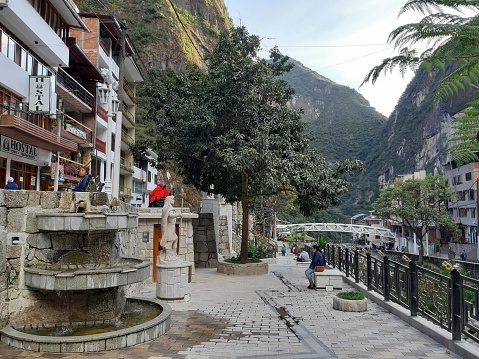 Scene Of Andes Mountain, Building Exterior, Retail Store, People Sitting Down, Standing, Walking Around And More At Aguas Calientes City Center In Cusco Peru South America