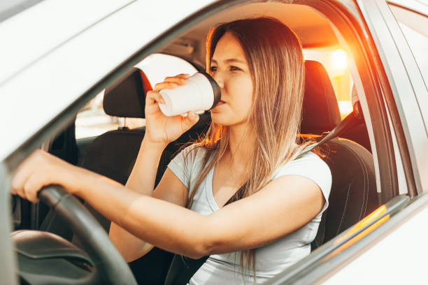 istock Woman driving and holding a coffee cup 1175554052