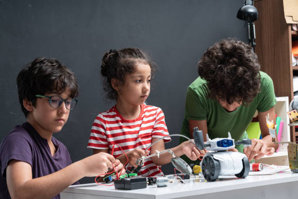 istock Three Children Working On Robotics In Front Of Blackboard 1175554100