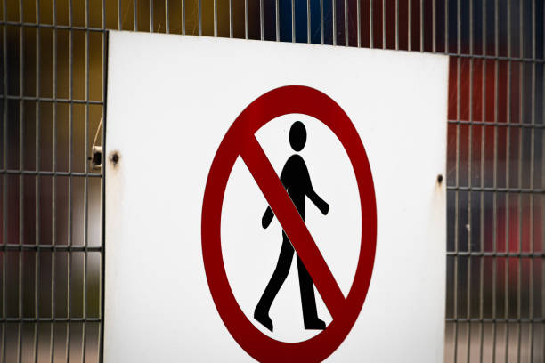 Sign attached to wire fence warning pedestrians that the area is out of limits.  Belfast, Northern Ireland.