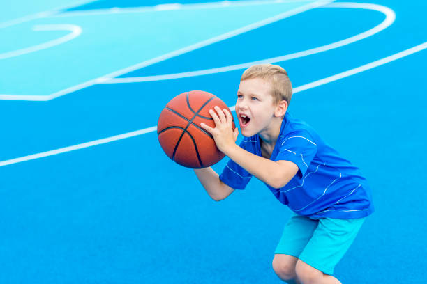 istock Young boy playing basketball isolated in blue 1175555992