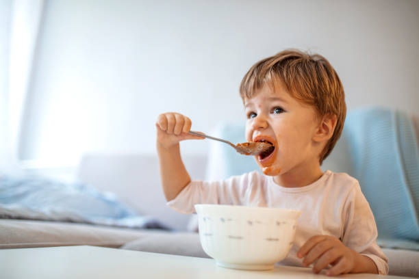 istock Eating cheerful baby boy with messy face. 1175556109