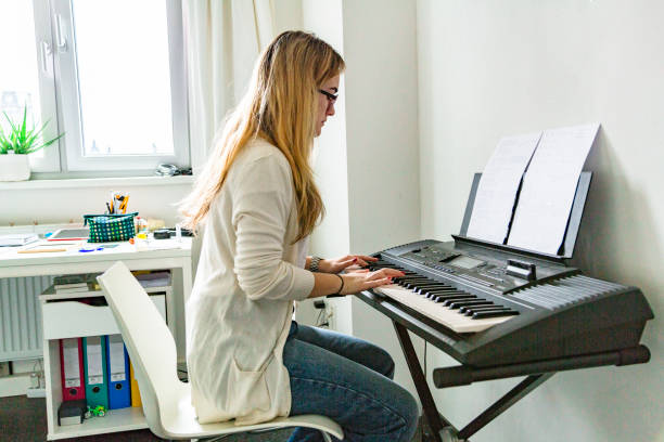 istock Young beautiful woman playing on piano at home 1175558493