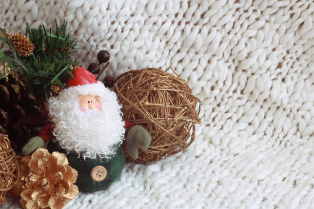 istock Santa Claus with Christmas decorations and cones is located on the side on a light background. New Year holiday greeting card 1175558907