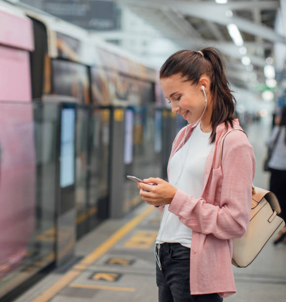 istock Young Woman Waiting for a Metro and Using a Cell Phone 1175562763