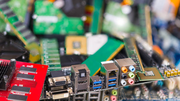 assorted connectors on a computer mainboard detail in a pile of discarded electronic waste. refuse disposal. bokeh - service electronics industry circuit board capacitor imagens e fotografias de stock