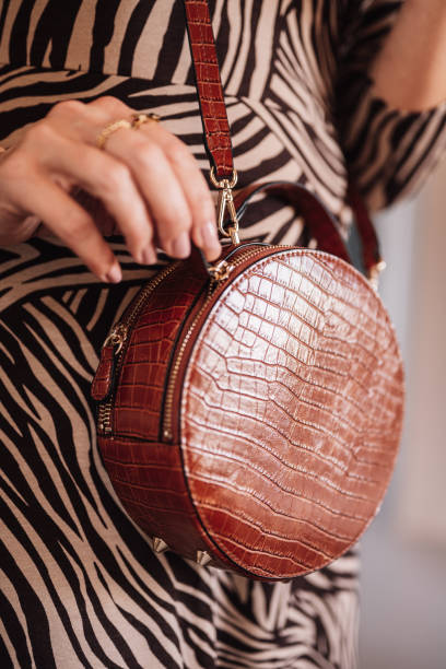 Woman and purse in animal print dress Woman and purse in animal print dress fake leather stock pictures, royalty-free photos & images