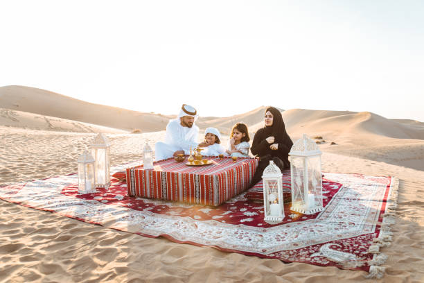 glückliche familie, die einen wunderbaren tag in der wüste mit einem picknick verbringt - liwa desert stock-fotos und bilder