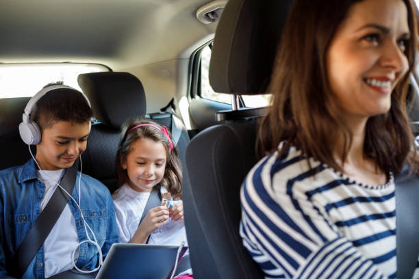 madre y sus hijos conduciendo juntos en el coche - seat belt audio fotografías e imágenes de stock