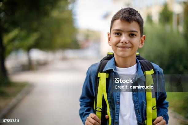 Smiling Teenage Boy With School Bag In Front Of School Stock Photo - Download Image Now
