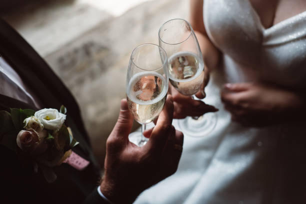 de cerca de pareja casada tosando copas de champán en la fiesta de bodas. manos novio gafas de clinking en la recepción de la boda. - clunking fotografías e imágenes de stock