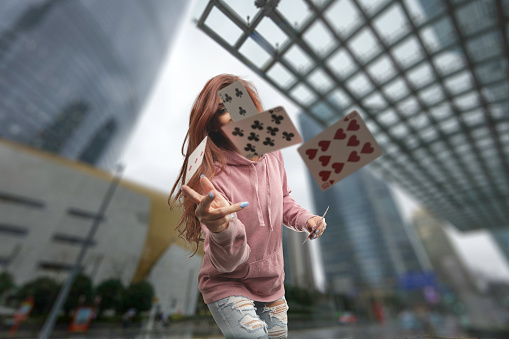 Woman throwing cards over camera