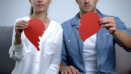Young family tearing into pieces paper heart, relationship problem concept