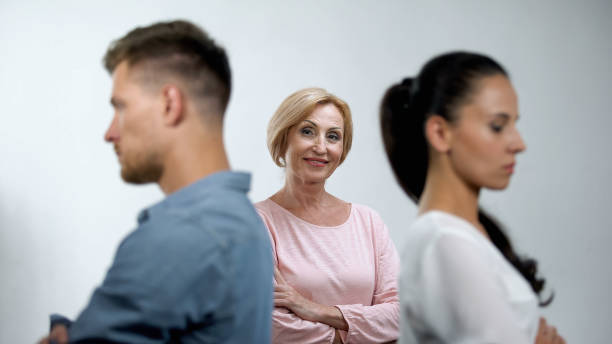 Satisfied mother looking at couple in quarrel standing back to each other Satisfied mother looking at couple in quarrel standing back to each other mother in law stock pictures, royalty-free photos & images