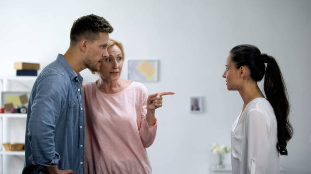 Mother getting on son side in conflict with wife, interference in relationship stock photo