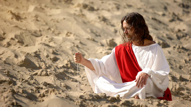 istock Philosopher pouring sand from hand in desert, reflecting on life and time 1175583528