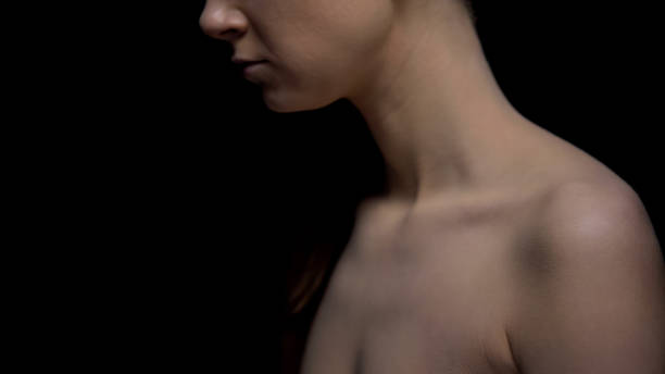 istock Naked female standing against black background 1175583576