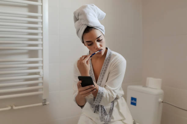 istock Woman wrapped in towel text messaging on smartphone 1175583589