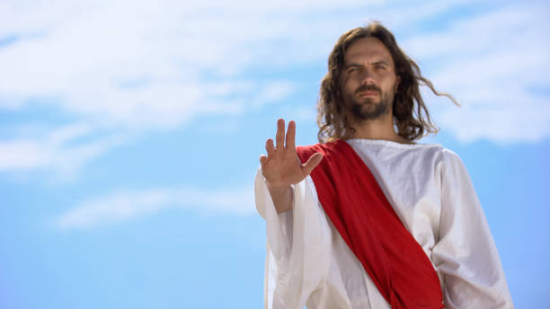 istock Jesus in robe stretching opened palm on camera, blessing and healing, template 1175583616