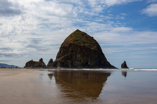 istock Cannon Beach, Oregon coast: the famous Haystack Rock reflects itself in the water 1175583629