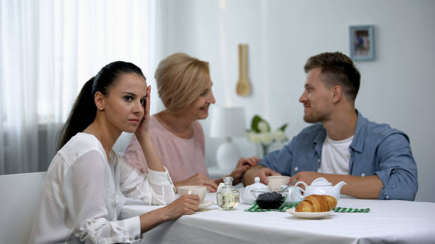 Mother-in-law and son talking and ignoring girlfriend, unhealthy relations Mother-in-law and son talking and ignoring girlfriend, unhealthy relations mother in law stock pictures, royalty-free photos & images