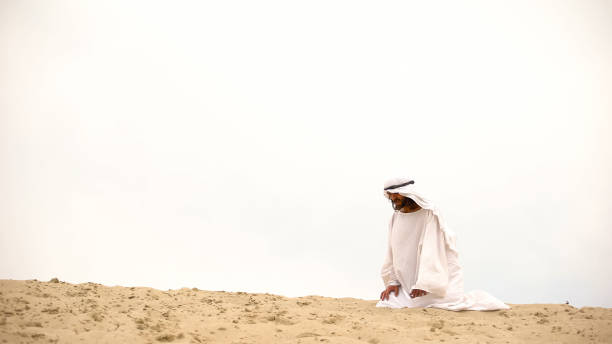 istock Tired Bedouin kneeling in desert, exhausted and lost, overcoming difficulties 1175584509