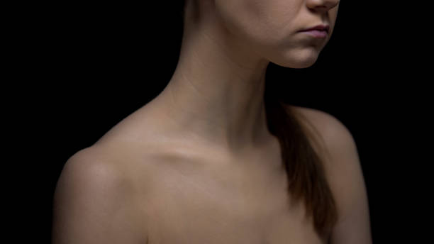 istock Naked female standing against black background, fighting insecurities concept 1175584564