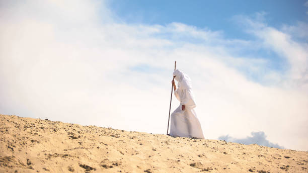 istock Tired Bedouin with staff walking in hot desert, climate change, global warming 1175584604